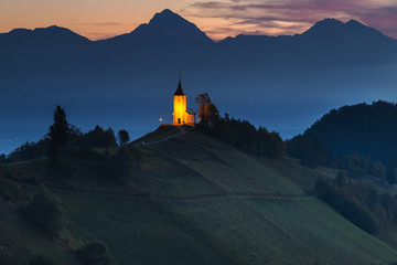 Obraz premium Autumn landscape of a beautiful church on the top of a hill, in Slovenia