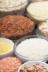 A set of bowls filled with different seeds: buckwheat, rise, corn and oatmeal	