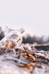 empty glass bottle lying on the sand on the beach