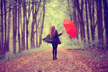 young woman dancing in an autumn park with an umbrella, spinning and holding an umbrella, autumn...
