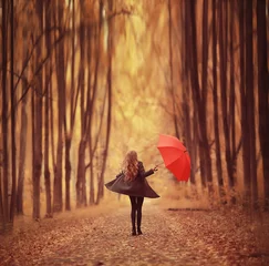 Junge Frau, die in einem Herbstpark mit einem Regenschirm tanzt, einen Regenschirm dreht und hält, Herbstspaziergang in einem gelben Oktoberpark © kichigin19