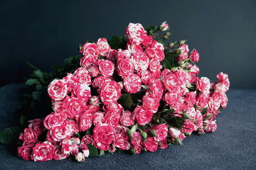 Bouquet of pink roses on grey textured background. Top view, copy space. Flat lay of Wedding, Women Day, Valentines Day, Mothers Day, birthday celebration concept. selective focus.  