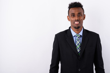 Young bearded African businessman wearing suit against white bac