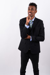 Young bearded African businessman wearing suit against white bac