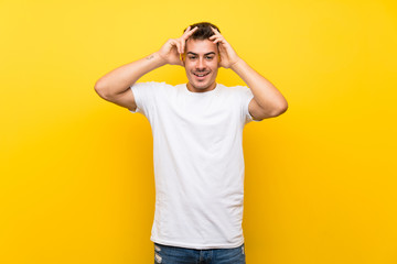 Young handsome man over isolated yellow background with surprise expression