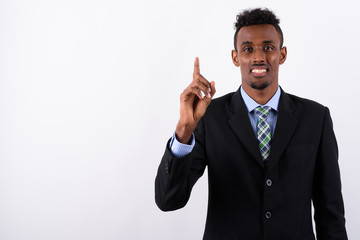 Young bearded African businessman wearing suit against white bac