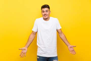 Young handsome man over isolated yellow background smiling