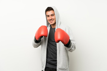 Sport man over isolated white wall with boxing gloves