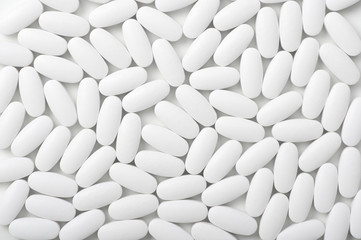 White pills (tablets) background. Top view