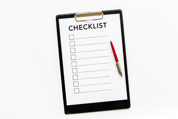Checklist and pen on white background top view copy space