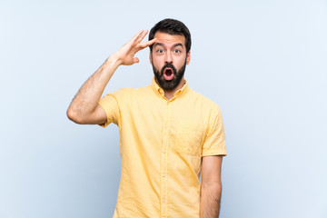 Young man with beard over isolated blue background has just realized something and has intending the solution