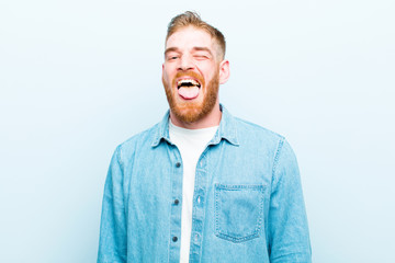 young red head man with cheerful, carefree, rebellious attitude, joking and sticking tongue out,...