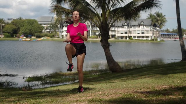 Active woman doing exercises on lakeside