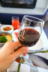 photo of Food served on board of business class airplane on the table. Glass of wine in an airplane business class