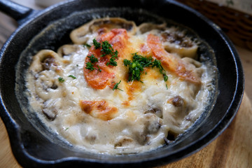 Lazy dumplings with mushrooms and cheese. Baked food in a pan.