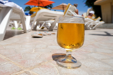 Summer holidays in the open air pool. Rest is all inclusive. Cold beer in a glass.