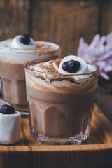 Happy  Halloween monster, pumpkin spice latte with big marshmallow eye