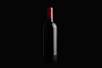 Botella de vino tinto sobre fondo negro aislado. Vista de frente. Copy space	