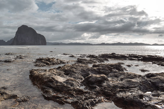 Sun shining over rocky limestone coastline in El Nido Palawan the Philippines