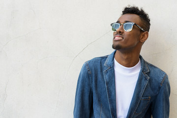 Young bearded African man wearing denim jacket and sunglasses ag
