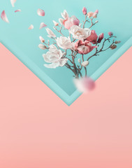 Envelope with pink white spring blossom branches and flying petals. Creative spring time layout in...