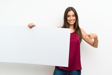 Young woman over isolated white background holding an empty white placard for insert a concept