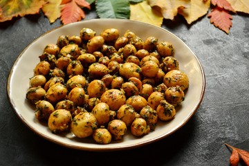 Fragrant fried champignons. Grilled mushrooms in a beautiful plate of pink color. Food on a wooden background. Autumn leaves. Autumn composition with food, with mushrooms.