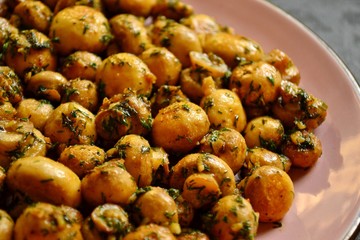 Fragrant fried champignons. Grilled mushrooms in a beautiful plate of pink color. Food on a wooden background. Autumn leaves. Autumn composition with food, with mushrooms.