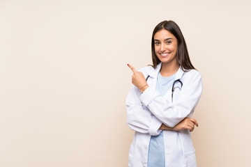 Young doctor woman over isolated background pointing finger to the side