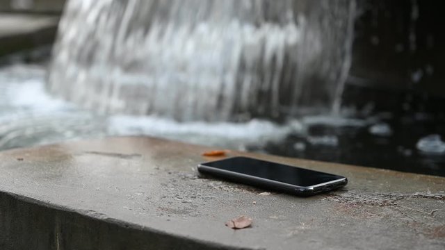Video concept of a waterfall flowing time with a smartphone in the park on an autumn day.