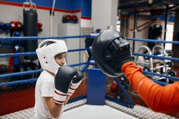 smiling boy gets pleasure from kickboxing, close up side view photo.