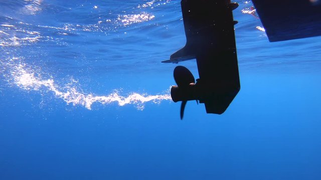 Underwater shot of boat propeller engine spinning.