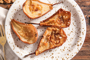 Plate with sweet cooked pears on table