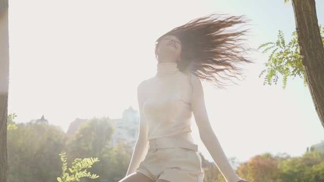 Young adult female sitting on fence and smiling nice