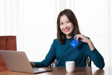 Happy Asian woman shopping online and paying by credit card.technology and ecommerce concept