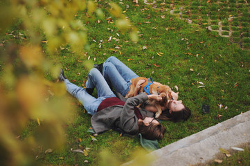 Woman with american cocker spaniel plays at autumn park