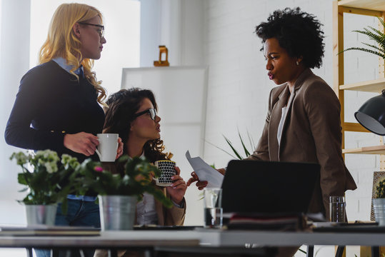 Women only business office. Woman entrepreneur. Diverse business team discussing work in their creative office.