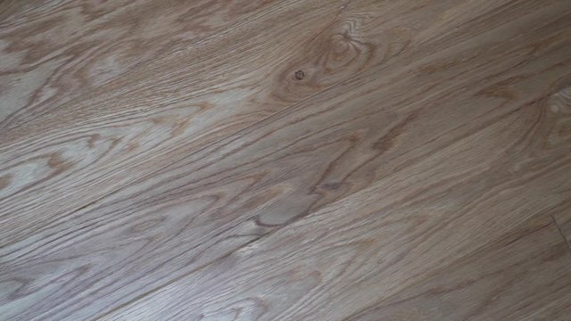 Close-up beautiful solid wood floor Board parquet light oak, circular slide camera