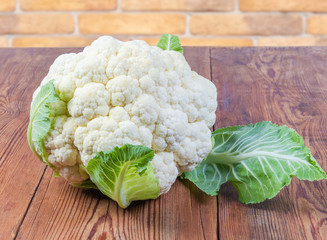 Whole raw cauliflower head on the old rustic table