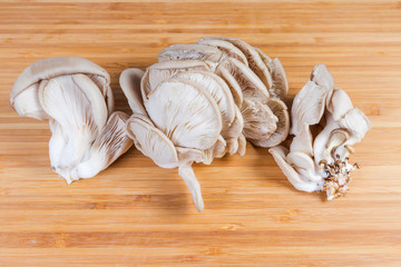 Raw oyster mushrooms on the wooden cutting board