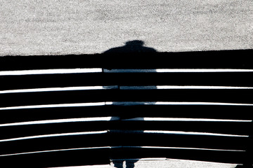 Abstract blurry shadow silhouette of a man on asphalt stairs
