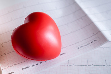 Close-up of red heart on electrocardiogram (ECG). Cardiology, health care and medicial concept.