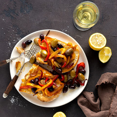Sandwiches with smoke peppers, olives and garlic on a light background, top view. Flat lay