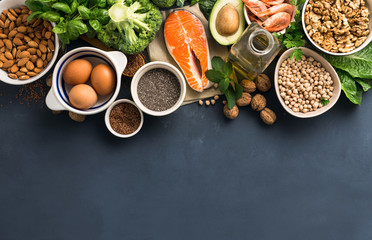 Food sources of omega 3 and healthy fats on dark background top view. Copy Space. Vegetables, seafood, nut and seed