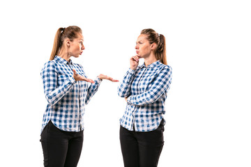 Young handsome woman arguing with herself on white studio background. Concept of human emotions,...