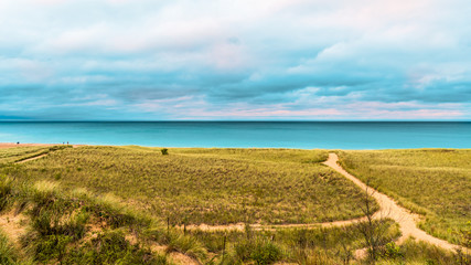 People walking the beach in New Buffalo Michigan by the dunes before it rains