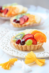 Beautiful cupcakes decorated with fresh fruits: grapes, peach, orange.