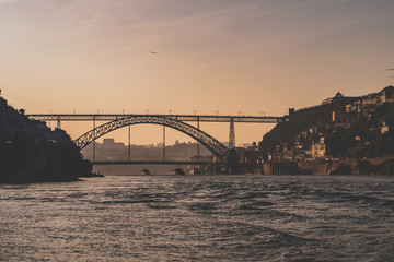 Luis I bridge with sunset and birds flying over in Porto, Portugal