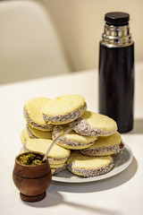 Mate and Delicious Argentinian and uruguayan cookies alfajores with cream on paper close-up on the table. Horizontal. Mate drink traditional in Uruguay, Argentina, Paraguay and Brazil.