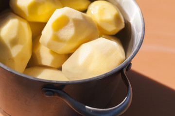 Raw peeled potatoes in a pan